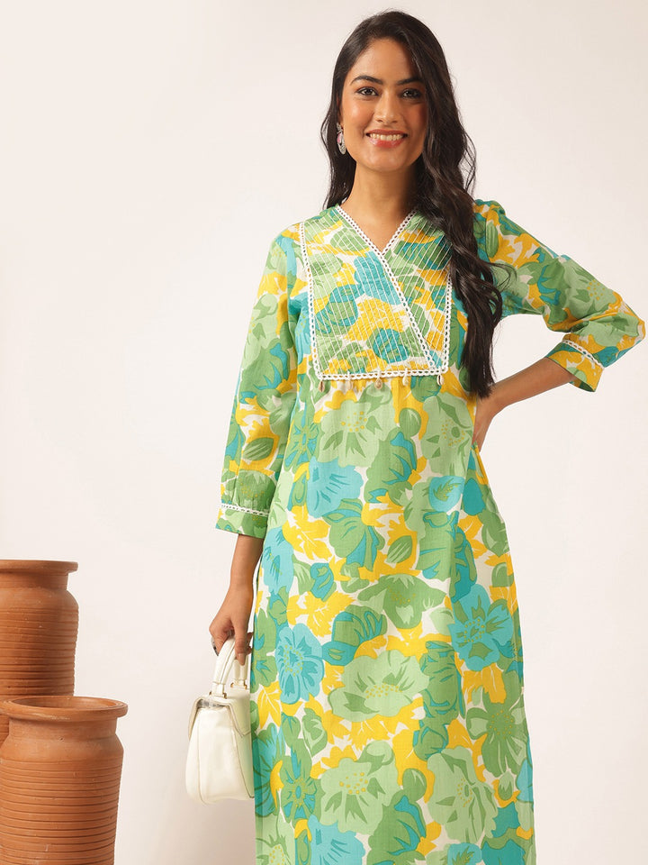 Woman wearing a green and yellow floral dress with terracotta pots in the background