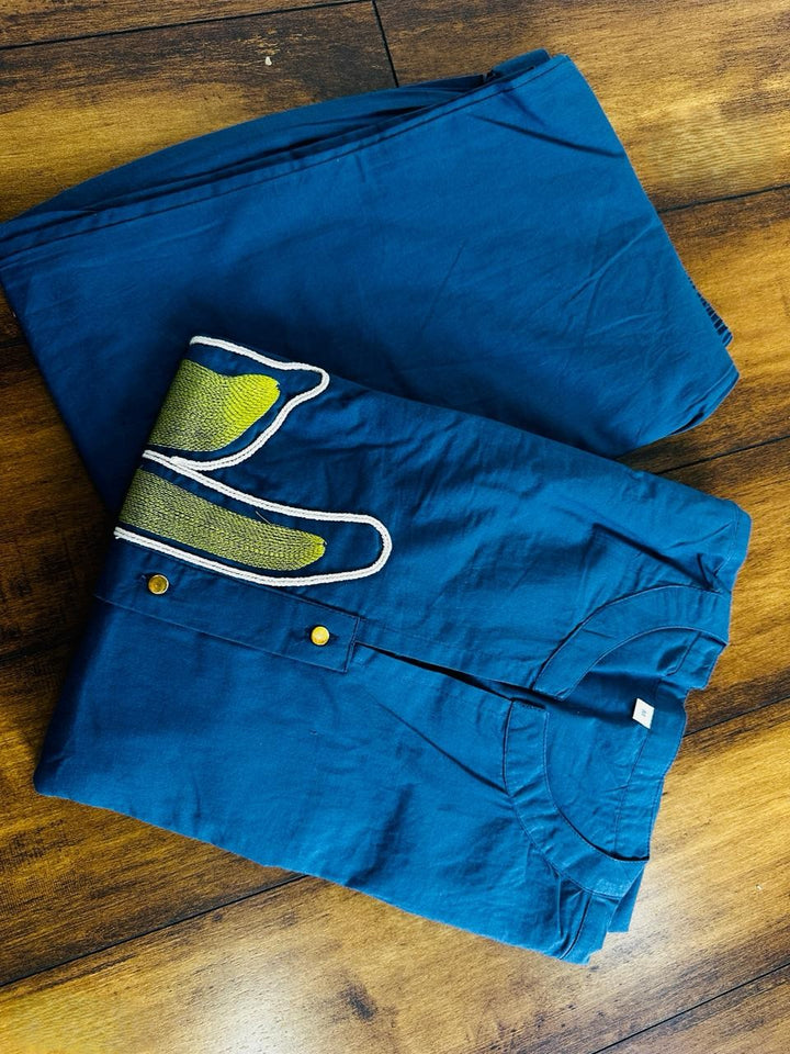 Folded blue shorts with a green and white design on a wooden surface