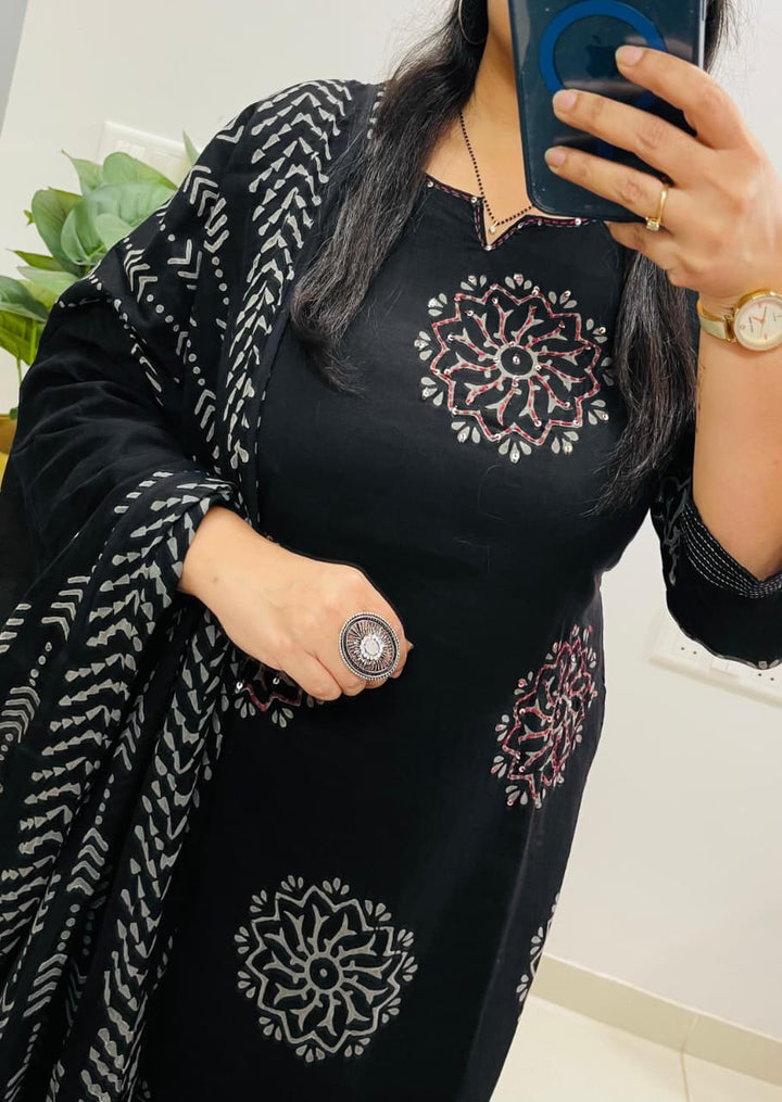 Person wearing a black outfit with white floral patterns