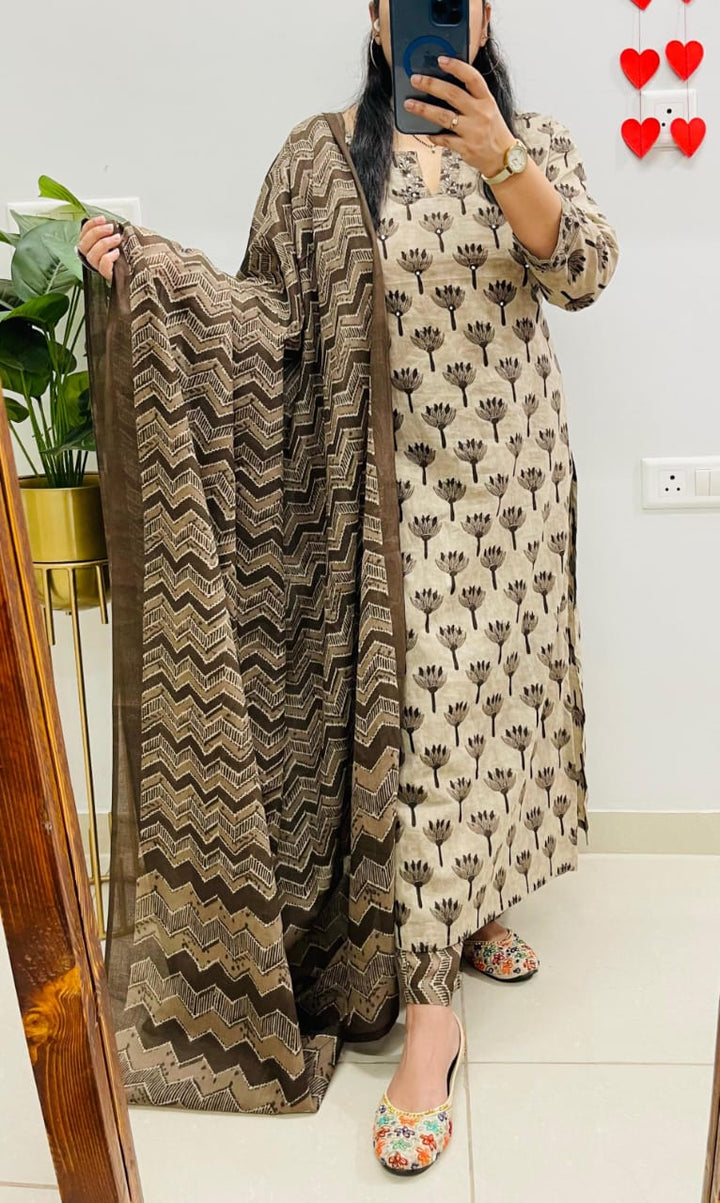 Person holding a patterned scarf in front of a mirror with a light-colored wall and decorative hearts in the background.