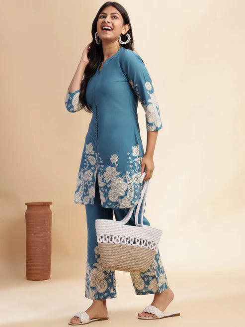 Woman wearing a blue floral outfit with a beige background