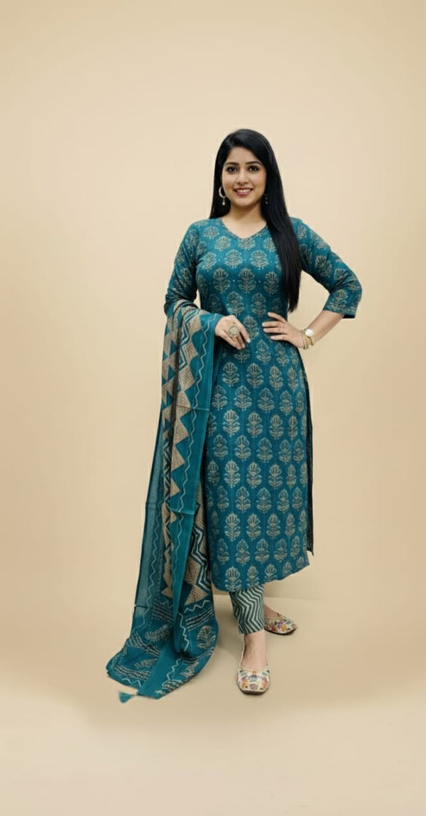 Woman wearing a teal traditional outfit with a matching dupatta on a beige background