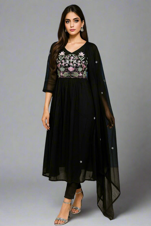 A woman wearing a black outfit with floral embroidery against a blue background with a logo.